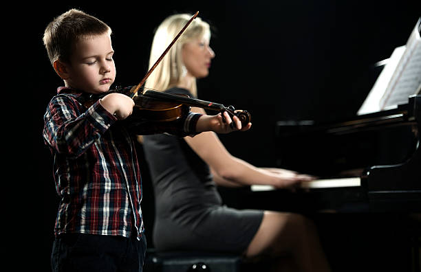 istock Little boy playing violin with his eyes closed. 488109080