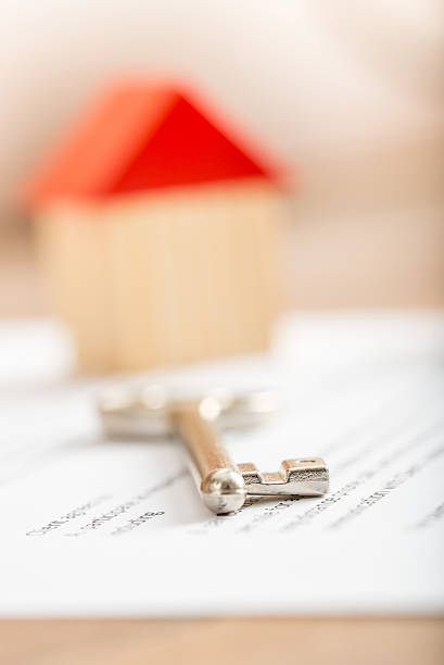 istock Silver house key lying on a contract for purchase 488109108