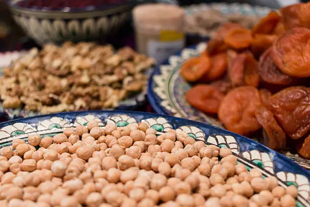 Dried fruits and chick peas on plates. Closeup of macro shot.