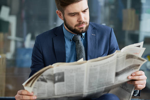 najnowsze wiadomości finansowe - newspaper reading broadsheet paper zdjęcia i obrazy z banku zdjęć