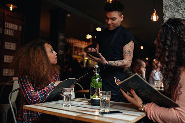 istock Young women giving order to a waiter at cafe 488119632