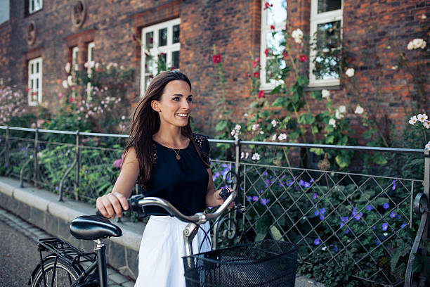 istock Woman with bicycle walking down the street 488119918