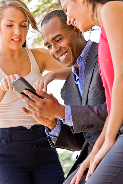 istock Multi-racial business people looking at cell phone 488120691