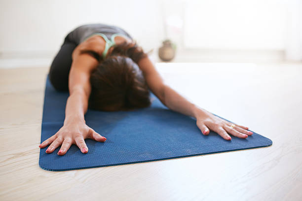istock Woman relaxing in child pose doing yoga 488120760