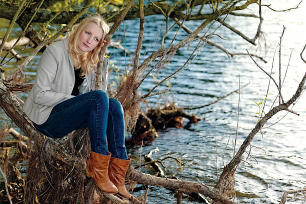 istock Blond melancholic woman sitting by a lake 488121683