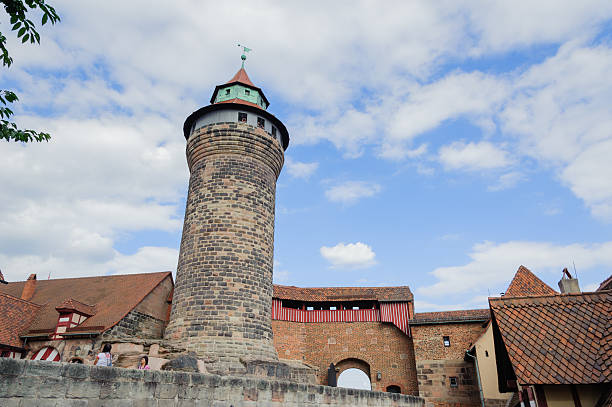 Imperial Castle in Nuremberg Nuremberg, Germany - August 8, 2012: Tourists visiting the Kaiserburg, one of the landmarks of the city of Nuremberg. The castle dominates the city from the hill and his profile, with towers and walls, characterizes the skyline of Nuremberg. kaiserburg castle stock pictures, royalty-free photos & images