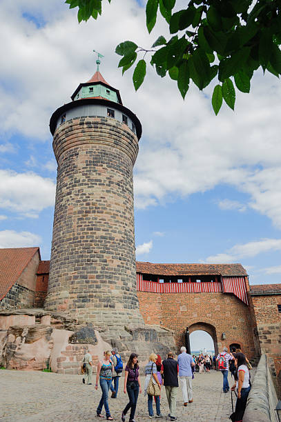 Imperial Castle in Nuremberg Nuremberg, Germany - August 8, 2012: Tourists visiting the Kaiserburg, one of the landmarks of the city of Nuremberg. The castle dominates the city from the hill and his profile, with towers and walls, characterizes the skyline of Nuremberg. kaiserburg castle stock pictures, royalty-free photos & images