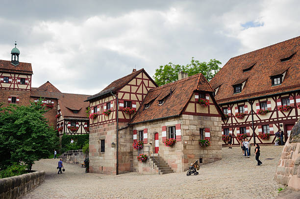 Castle in Nuremberg Nuremberg, Germany - August 8, 2012: Tourists visiting the Kaiserburg, one of the landmarks of the city of Nuremberg. The castle dominates the city from the hill and his profile, with towers and walls, characterizes the skyline of Nuremberg. kaiserburg castle stock pictures, royalty-free photos & images