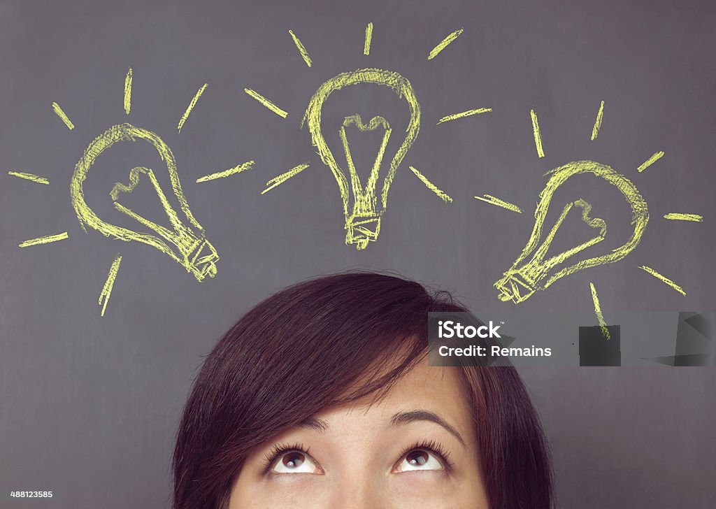 Frau sieht auf Glühbirne - Lizenzfrei Glühbirne Stock-Foto