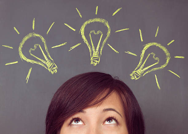 istock Woman looks up on light bulb 488123585