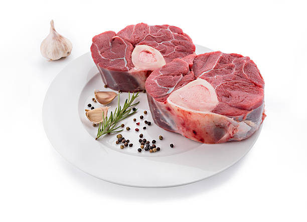 Raw veal shank for making OssoBuco Raw fresh cross cut veal shank and seasonings for making Osso Buco ossobuco stock pictures, royalty-free photos & images