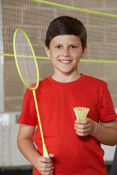 portrait de garçon à l'école de jouer au badminton - badminton school gymnasium shuttlecock sport photos et images de collection