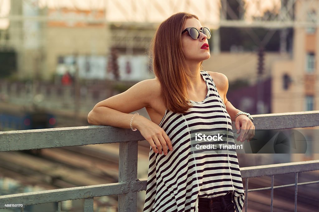 On the bridge Lonely girl standing on the bridge. Toned image 2015 Stock Photo