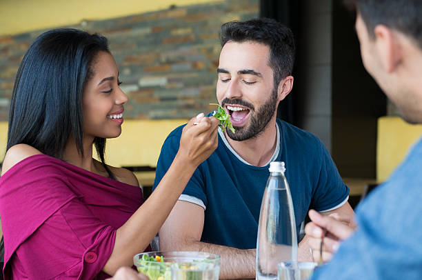 istock Young woman feeds salad to man 488150648