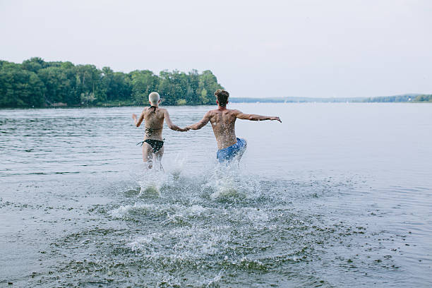 Good friends running into the lake
