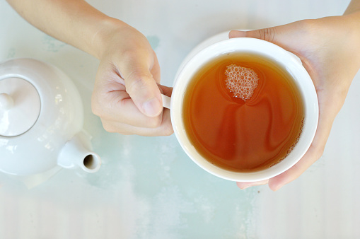 Hands of a woman with a cup of tea