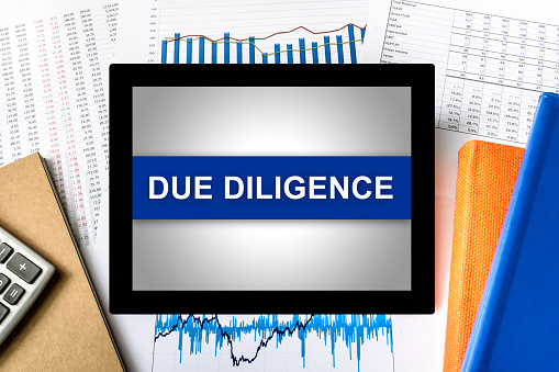 due diligence word on tablet with financial graph background