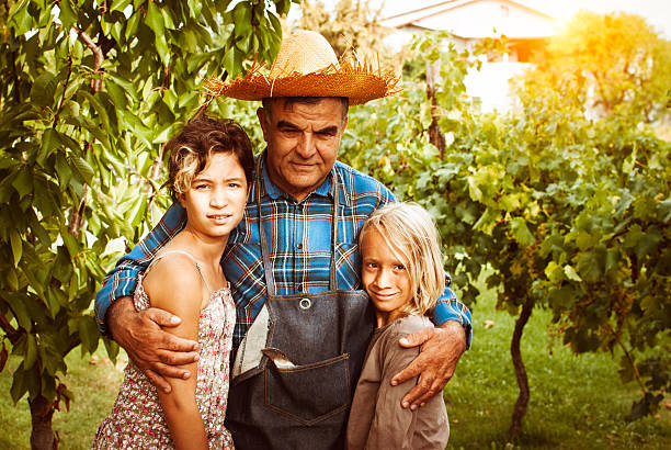 nonno con i suoi nipoti - casual granddaughter farmer expressing positivity foto e immagini stock