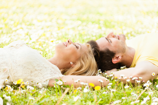 Couple lying down on the grass.
