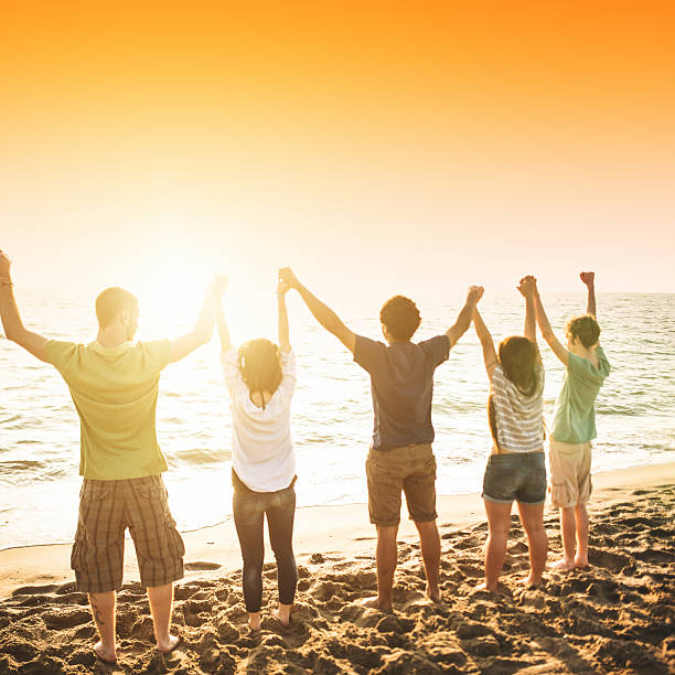 istock volunteer with arm raised at sunset 488159019
