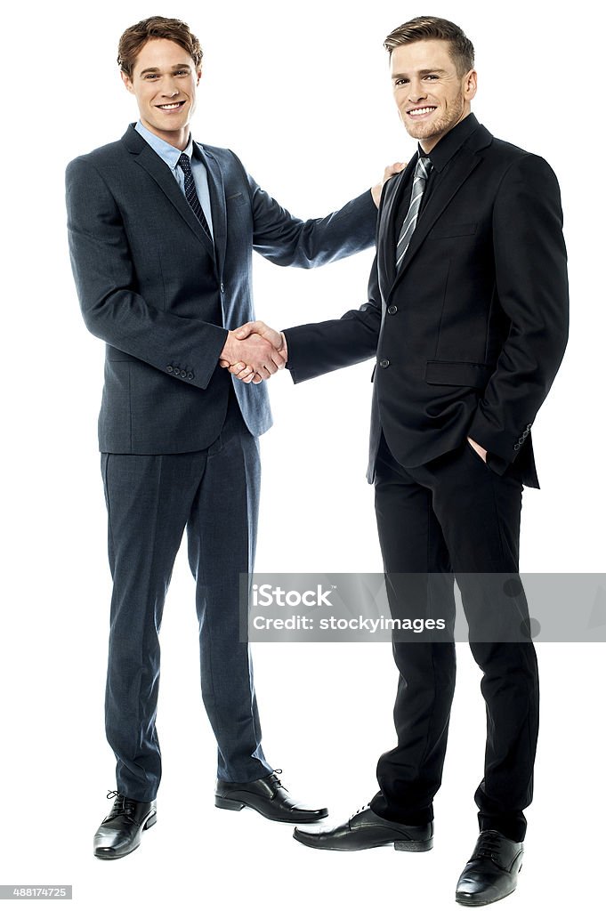 Business colleagues are now partners Handsome businessmen shaking hands Handshake Stock Photo
