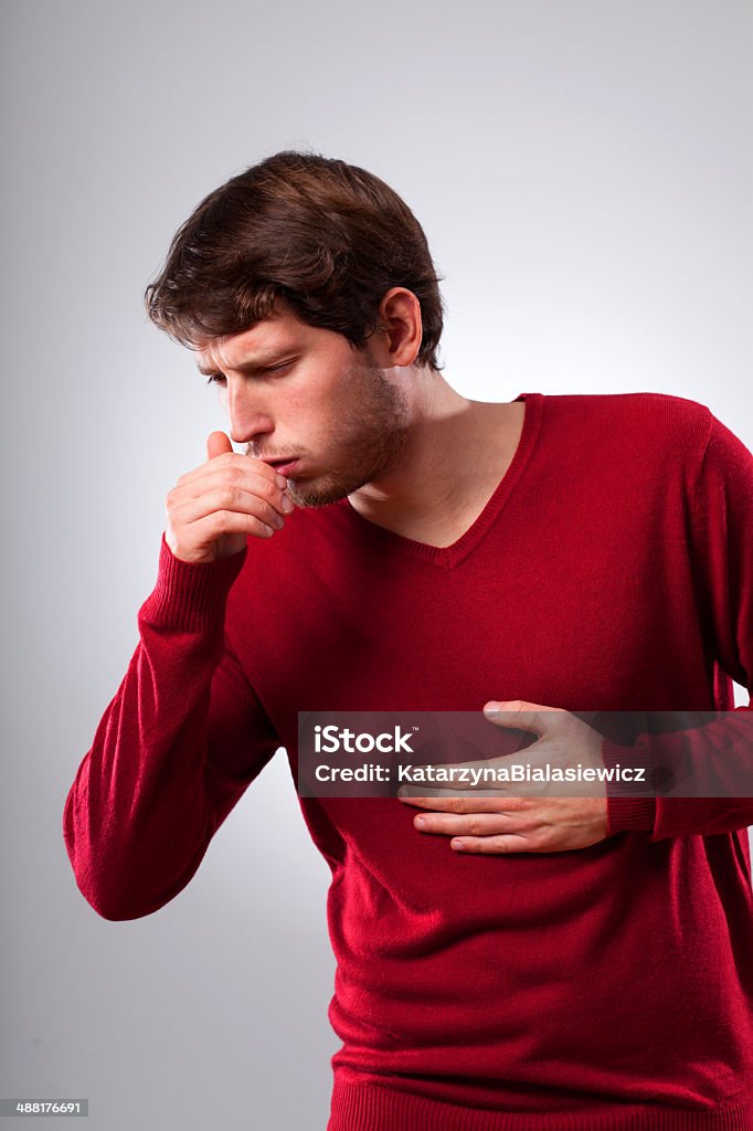 Man suffering from strong cough Young man suffering from strong cough, vertical Adult Stock Photo