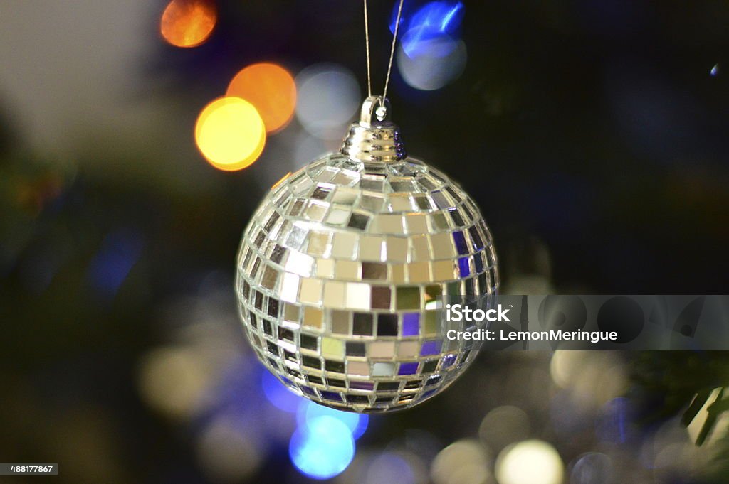 Silver mirrored bauble A silver mirrored bauble hanging on a tree. Cheerful Stock Photo