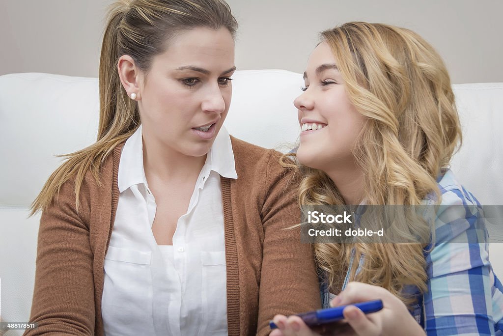 Surprised mother when looking phone of daughter Surprised real mother when looking a smartphone of her daughter at home Daughter Stock Photo