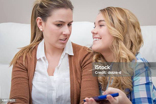 Surprised Mother When Looking Phone Of Daughter Stock Photo - Download Image Now - Daughter, Suspicion, Adolescence