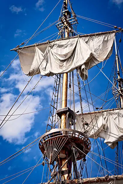 Old sailing ship mast against blue sky
