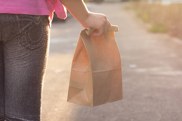 Child walking to school, with lunch bag stock photo