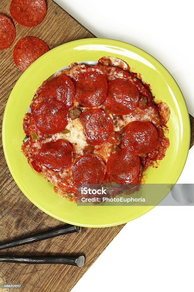 Microwaved Frozen Pizza on Table Microwaved Frozen Pizza in Plate on Table Cheese Stock Photo