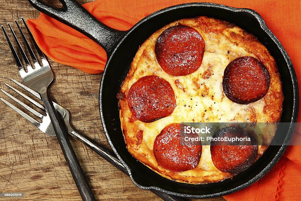 Skillet Peperonni Pizza on Table Pizza Stock Photo