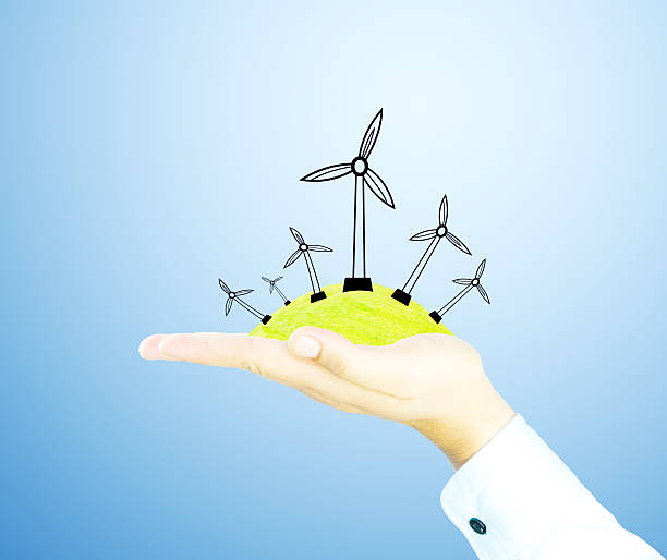istock wind generator on green wolrd nature by hand 488202933