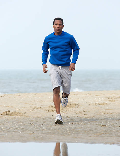 istock African american man jogging at beach 488206827