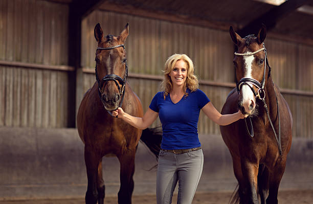 istock woman walking with two horses 488208200