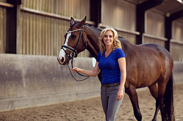 istock blonde holding her horse 488209206
