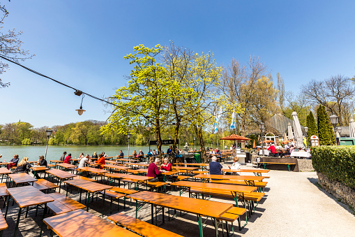 Munich, Germany - April 20, 2015: people enjoy the beautiful weather at the   Seehaus in Munich, Germany. This Beergarden is placed at the Kleinhesseloher lake in the English Garden.