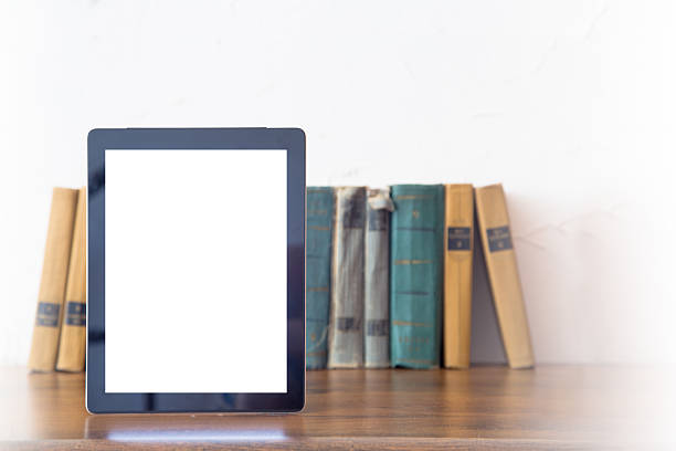istock Stack of old books and tablet over wooden table 488209954