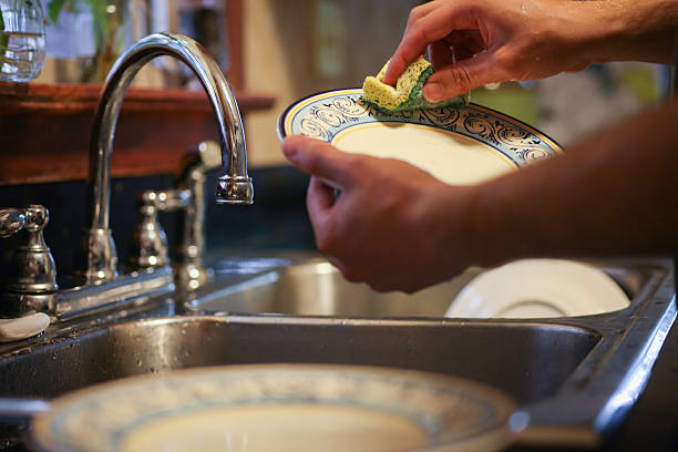 washing dishes in the sink stock photo