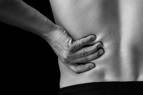 Pain in the lower back, close-up Man touches the lower back, pain in the kidney, monochrome image, close-up backache photos stock pictures, royalty-free photos & images