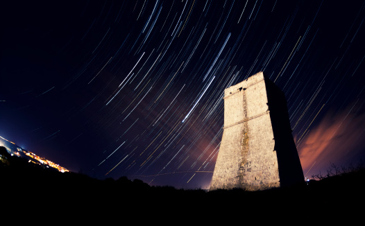 Star trails over an ancient Maltese Tower.