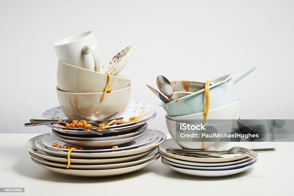 Dirty dishes pile needing washing up on white background Dirty dishes pile needing washing up. Household chore concept on white background Washing Dishes Stock Photo