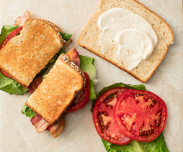 BLT Sandwich Bacon, Lettuce and Tomato Sandwich with bread slice smeared with mayonnaise and tomatoes on the side mayonnaise photos stock pictures, royalty-free photos & images