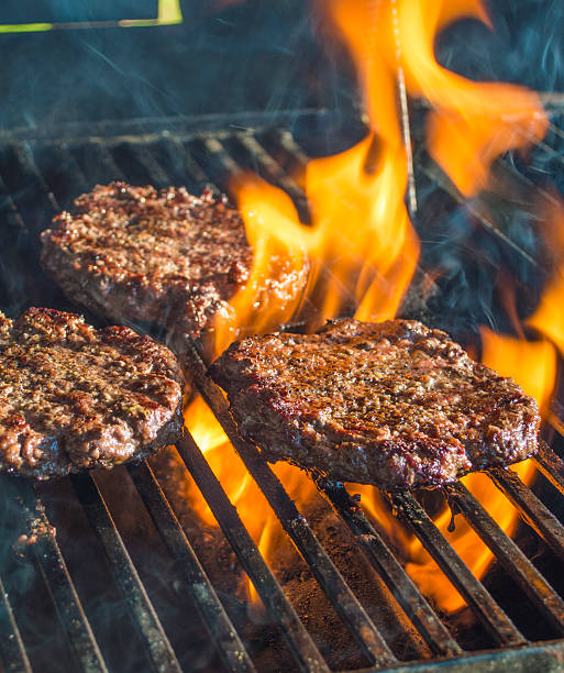 istock Hamburgers on a hot flaming grill 488224421