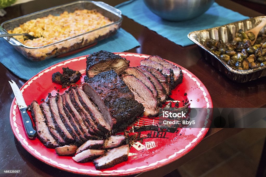 Texas BBQ Brisket Platter Delicious Texas Smoked Prime Brisket, Sliced and served on a traditional red platter along with mac & cheese and grilled brussel sporuts. Barbecue - Meal Stock Photo