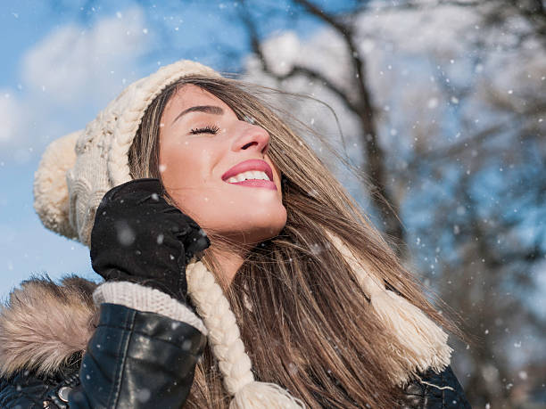 istock Girl enjoying snow with eyes closed with wool hat 488239550