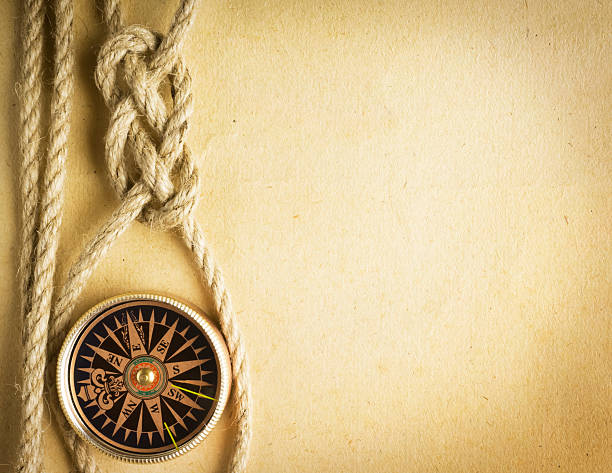 istock Rope and compass on the old paper background 488239977