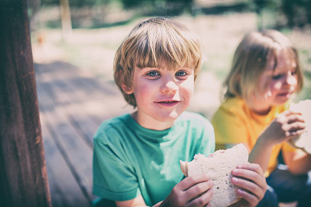 istock Children eating lunch on a porch step 488240830