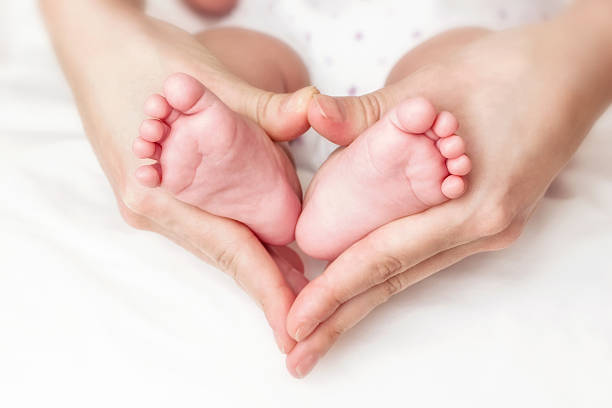 Newborn baby feet in the mother hands
